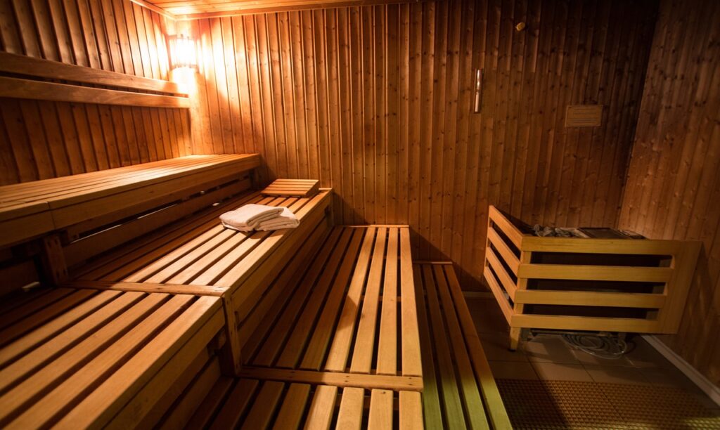 Sauna en bois vide, avec deux serviettes disposées soigneusement sur des bancs, sans personnes à l'intérieur.